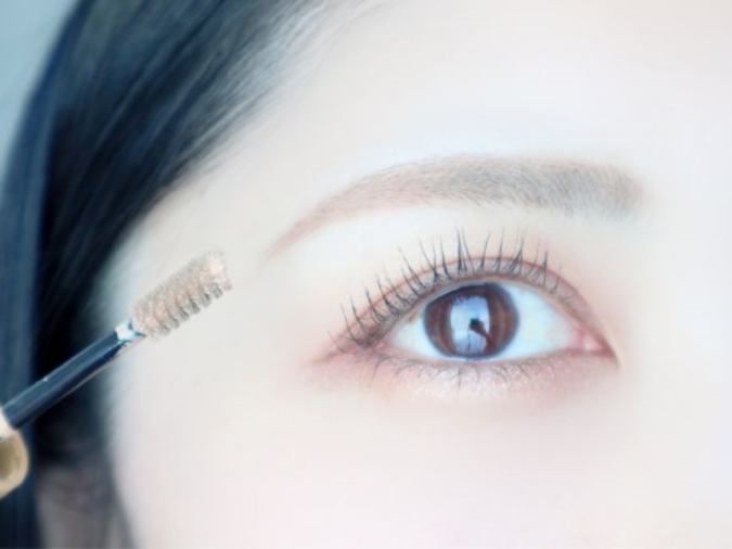 リキッドタイプのコンシーラーを眉毛になじませている