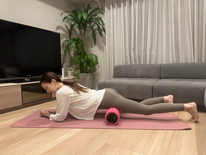 うつ伏せになって、フォームローラーを太ももの付け根の下に置き、前後に転がす。