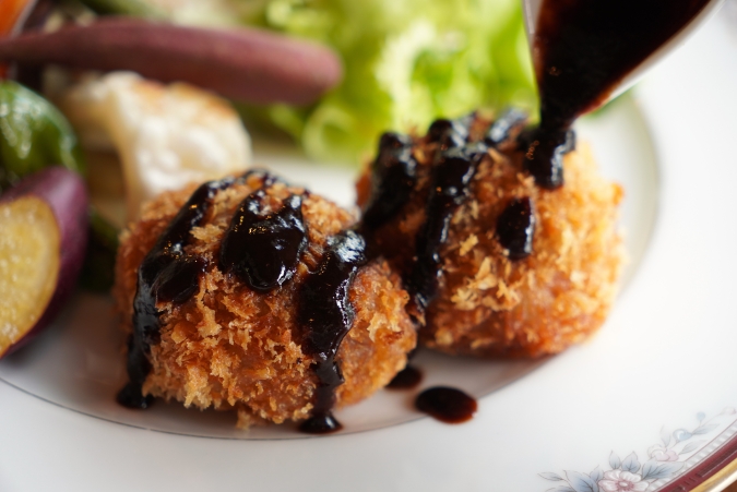 シークレットレストランK　ジビエのメンチカツ　自家製ウスターソースをかけるシーン