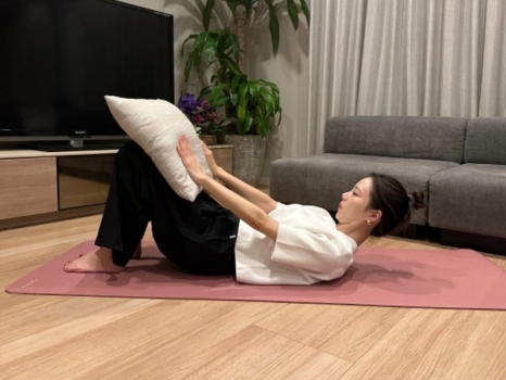 両手でクッションを軽く押し、息を吐きながら、少しだけ頭を持ち上げる。（首〜肩が床から浮くくらい）