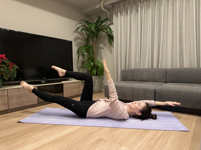 息を吐きながら、お腹を薄くしたまま、右手を頭の方へ、左脚を斜め前へゆっくり伸ばす。