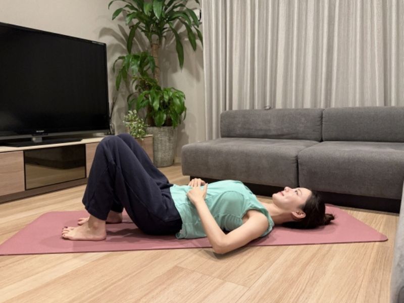 あお向けに寝て、軽く膝を立て、肋骨のいちばん下のフチに、指4本を添える。