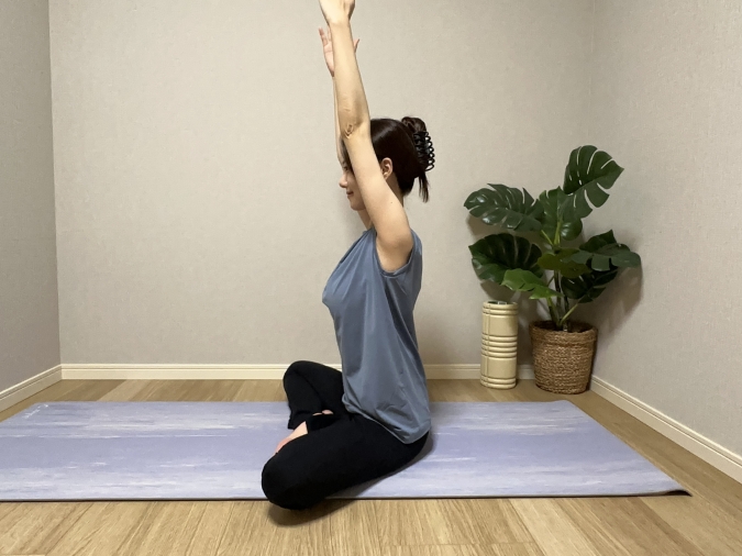 両腕を上にまっすぐ伸ばし、背筋を伸ばす。