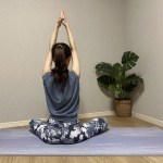 座った体勢で、背筋を伸ばし、両手を天井に向かって上げ、手のひらをあわせる。