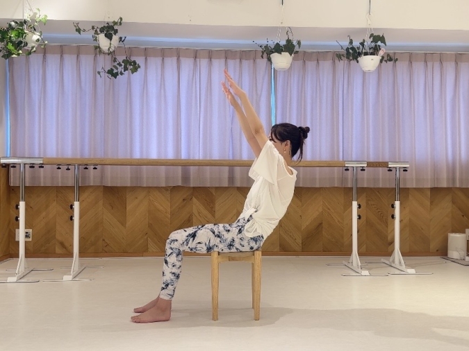 息を吸いながら両手を頬骨の延長線の高さまで伸ばす。